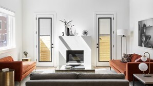 A modern living room with a fireplace, two sofas, a coffee table, and a floor lamp. - Absolute Luxury! Sleeps 16! RoofDeck/Gym/Wet Bar (Philadelphia)