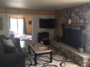 A living room with a stone fireplace, a flat-screen TV, and a sofa. - The Golden Getaway, #A (Crestone)