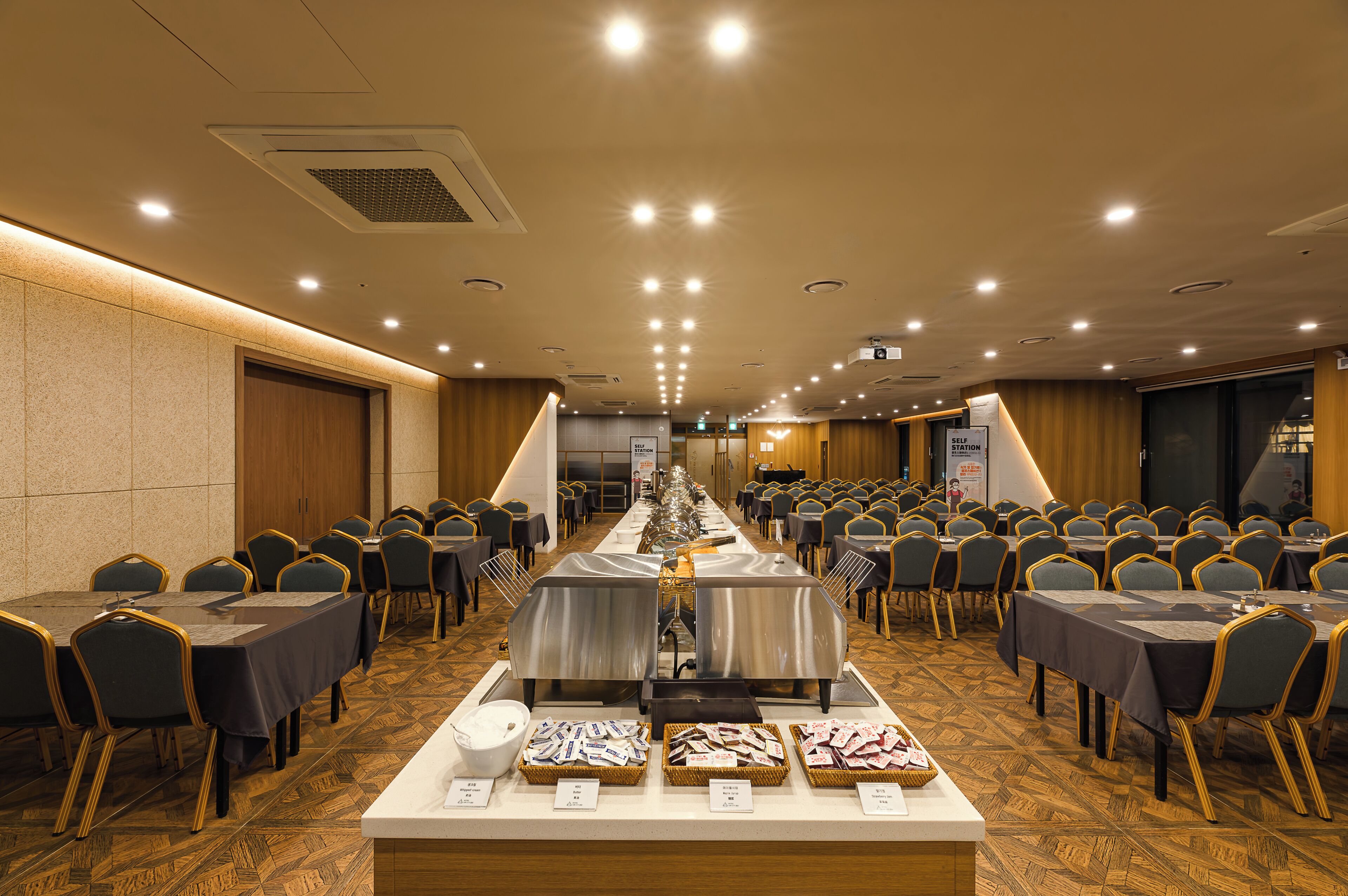 A conference room with a long table, chairs, and buffet area.