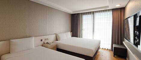 A hotel room with two beds, a nightstand, a TV, and a window with curtains.