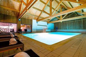 Relax by the rectangular pool surrounded by lounge chairs and towels.