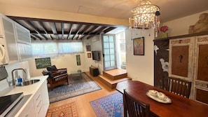 A kitchen with a wooden table, a bar area, and a dining table with chairs. There is a staircase leading to a lofted area. - Artistic Haven in Hollywood with Pool, Hot Tub, Cabana, and Garden (Los Angeles)