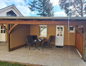 A covered patio area with a brick wall, two windows, and a door marked with the number 10.