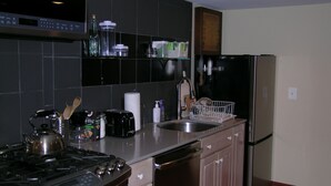 Una cocina equipada con estufa, tostadora, lavaplatos y refrigerador.