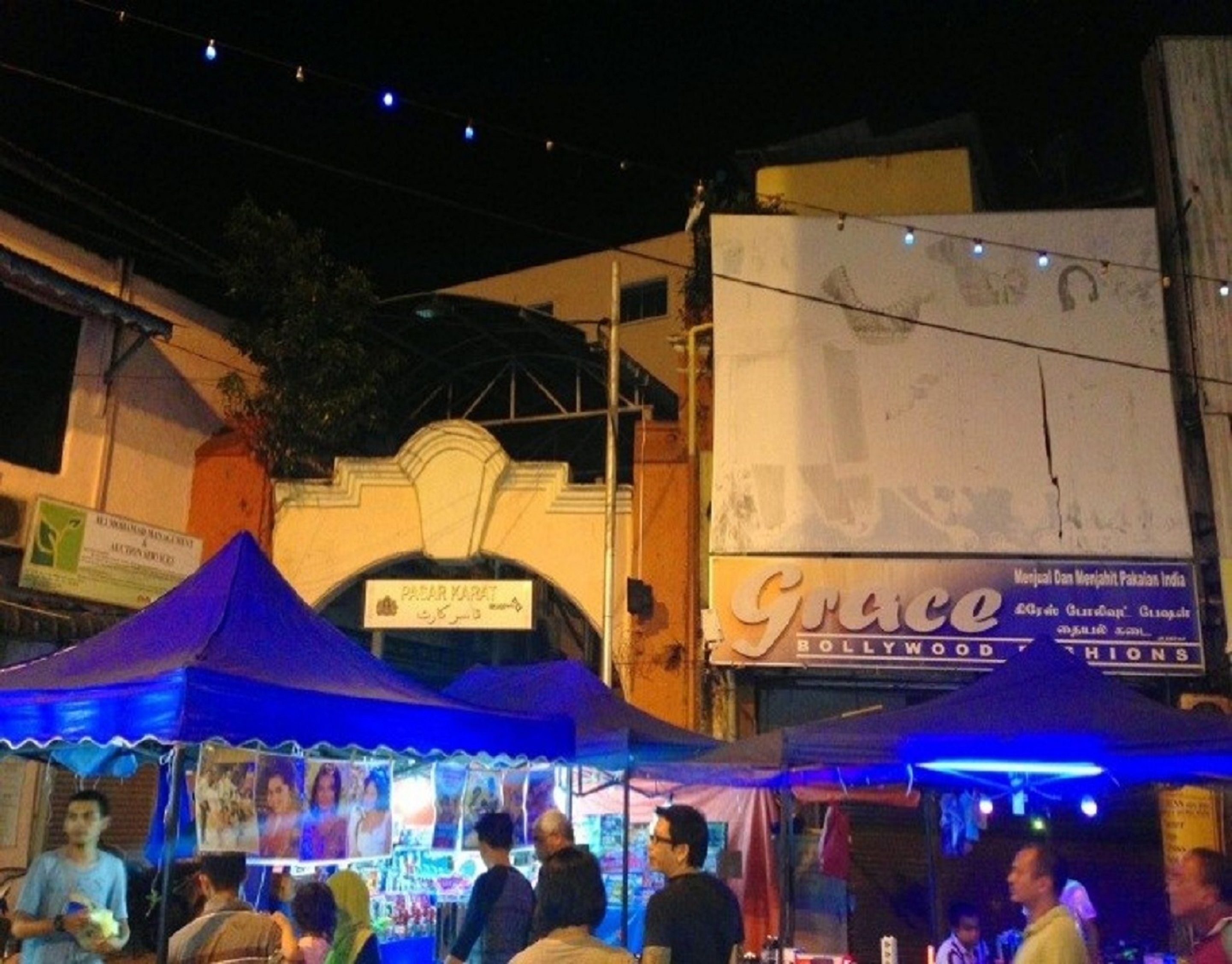 A street scene with a blue tented stall and a building with a sign that reads "Grace".