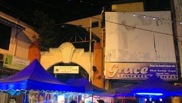 A street scene with a blue tented stall and a building with a sign that reads "Grace".