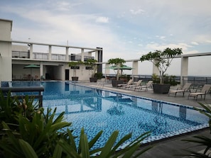 A rooftop pool with clear blue water, surrounded by lounge chairs and potted plants. - H Elite Design Hotel (Kota Bharu)