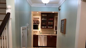 A hallway leading to a kitchen with a refrigerator, dishwasher, and wooden cabinets. - Super Location. Close to about everywhere .Great value.Over 200 reviews!! (Richmond)