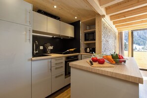 A modern kitchen with white cabinets, stainless steel appliances, and a wooden ceiling. - Grand Roc C411 280m from Slopes, Mont-Blanc View, Parking & WiFi, Argentière (Chamonix), France (Argentière (Chamonix))