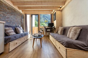 Ein modernes Interieur mit einer Couch, einem kleinen Tisch und einem Schreibtisch mit einem Computer.