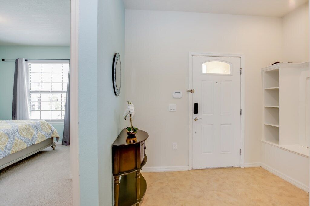 Un dormitorio con cama, cómoda, puerta y ventana.