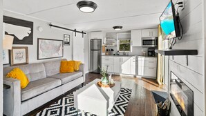A modern living room with a grey sofa, a coffee table, and a fireplace.