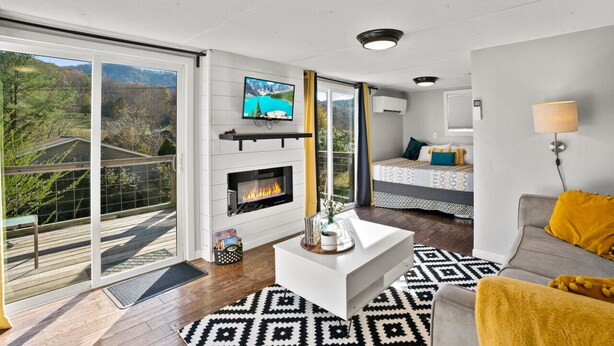 A modern living room with a fireplace, a television, and a sofa.