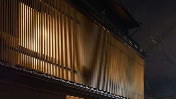 Un edificio moderno con techo inclinado y paneles de madera verticales.