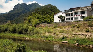 A hotel with a view of a river and mountains. - Lv ye Xian Zhuang Guesthouse (Taizhou)