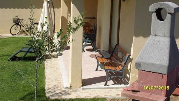 A patio area with a grill, outdoor furniture, and a bicycle. - Sardinia-Pittulongu-Holiday home w/ garden 5 min. walk from withe sandy beaches (Olbia)