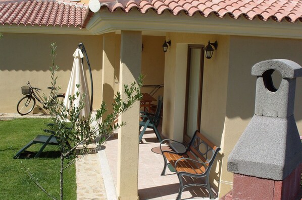 A patio area with a grill, outdoor furniture, and a bicycle.
