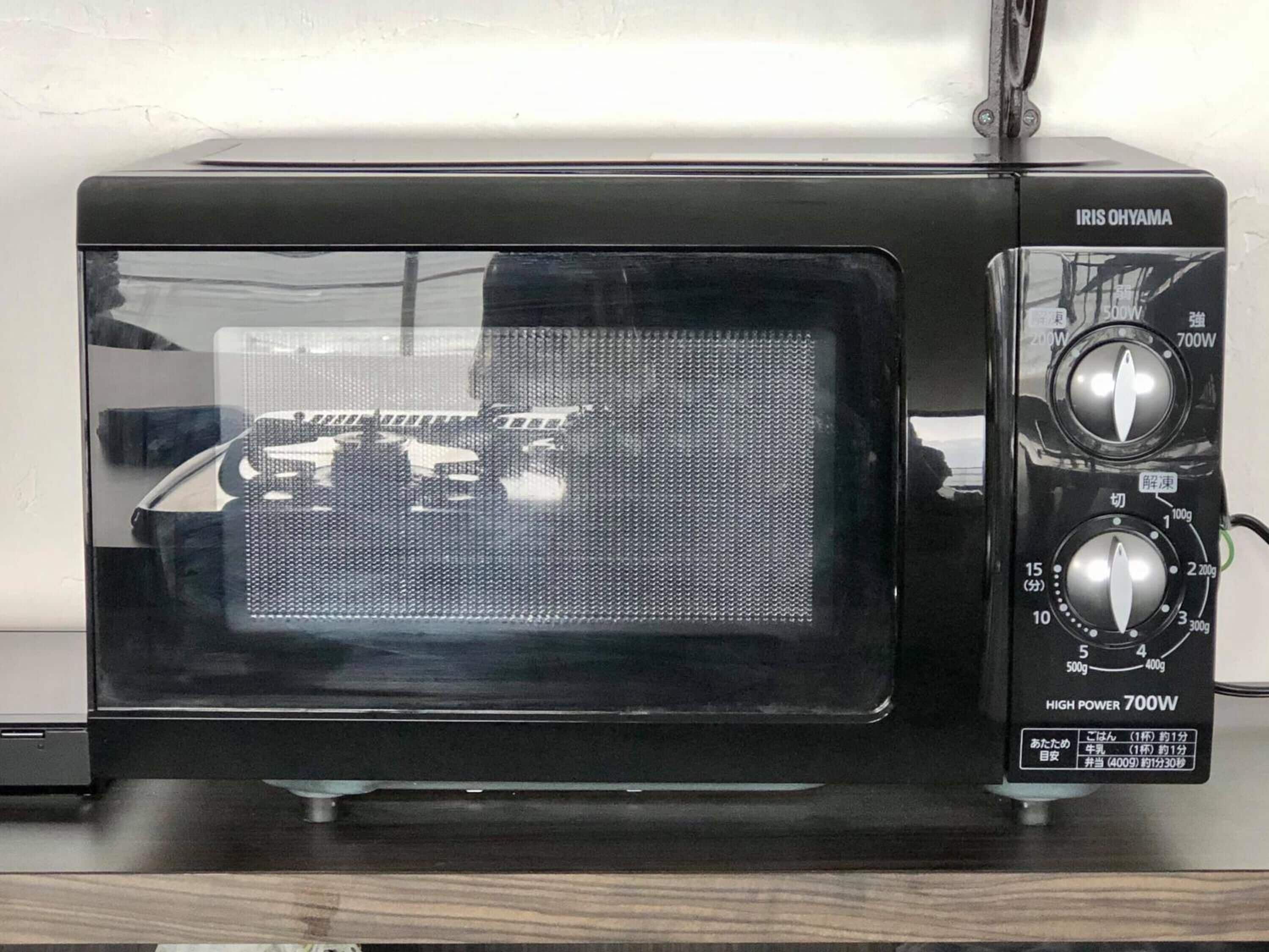 A black IRIS OHYAMA microwave with a digital display, power settings, and a timer.