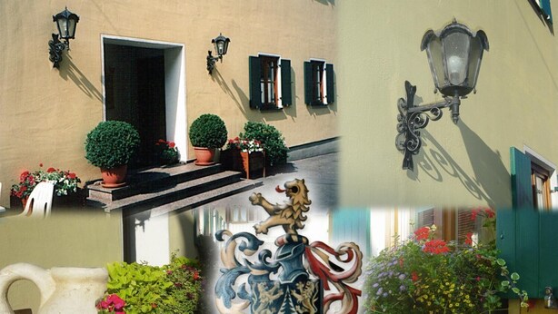Une façade d’immeuble avec une porte, des fenêtres et des luminaires d’extérieur.
