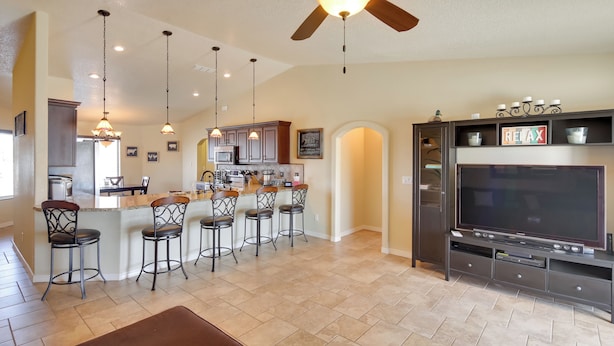 A spacious kitchen with a bar area, a large TV, and a ceiling fan. - Pool, Hot Tub & Mtn Views: Lake Havasu City Home! (Lake Havasu City)