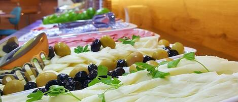 Una mesa de buffet con diversos alimentos y un centro de mesa decorativo.