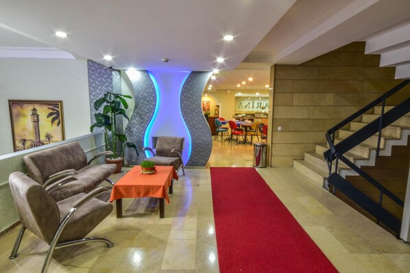 A hotel lobby with a red carpet, a reception desk, and a staircase. - Marina Hotel (Izmir)