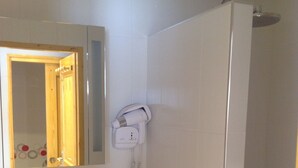 A bathroom with a white sink, a mirror, a towel rack, and a shower area. - APPT. T 3 IN CHALET (Saint-Sorlin-d'Arves)