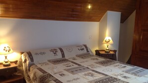 A bedroom with a large bed, two bedside tables with lamps, wooden ceiling, and a wooden wardrobe. - APPT. T 3 IN CHALET (Saint-Sorlin-d'Arves)