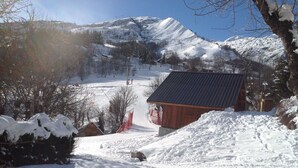 A snow-covered mountain landscape with a wooden cabin and a ski slope in the background. - APPT. T 3 IN CHALET (Saint-Sorlin-d'Arves)