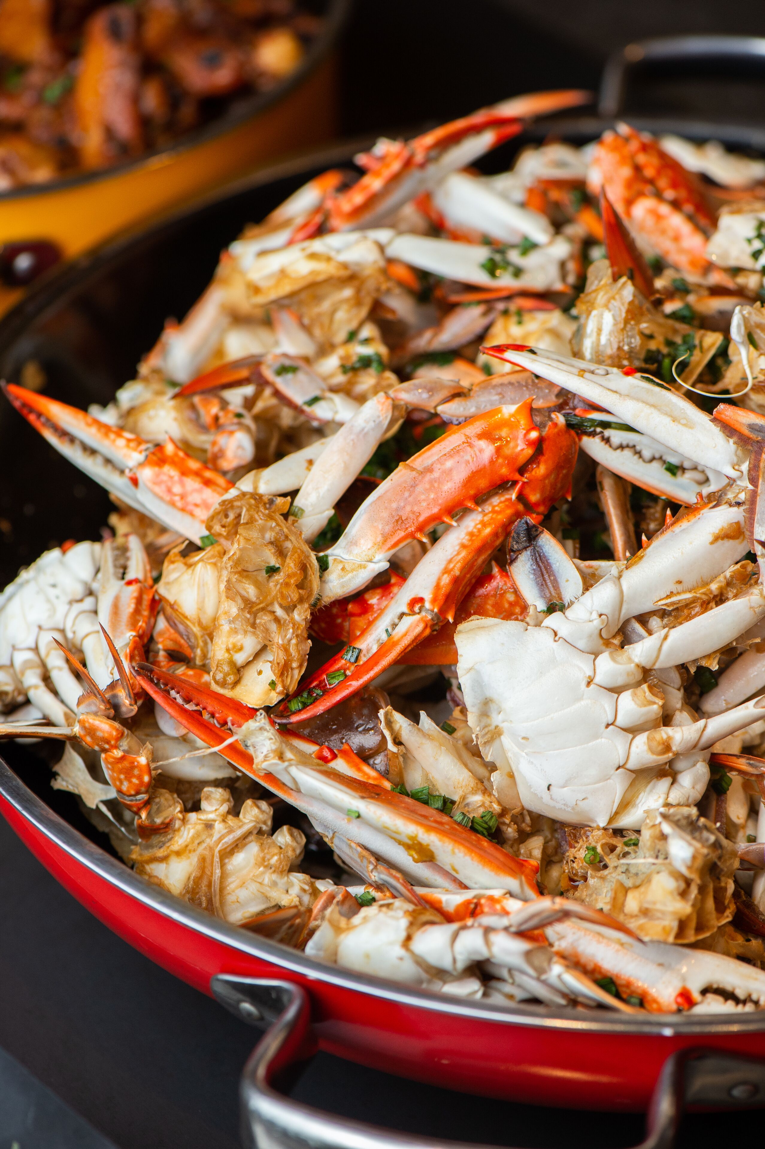 A red pan filled with cooked crabs.