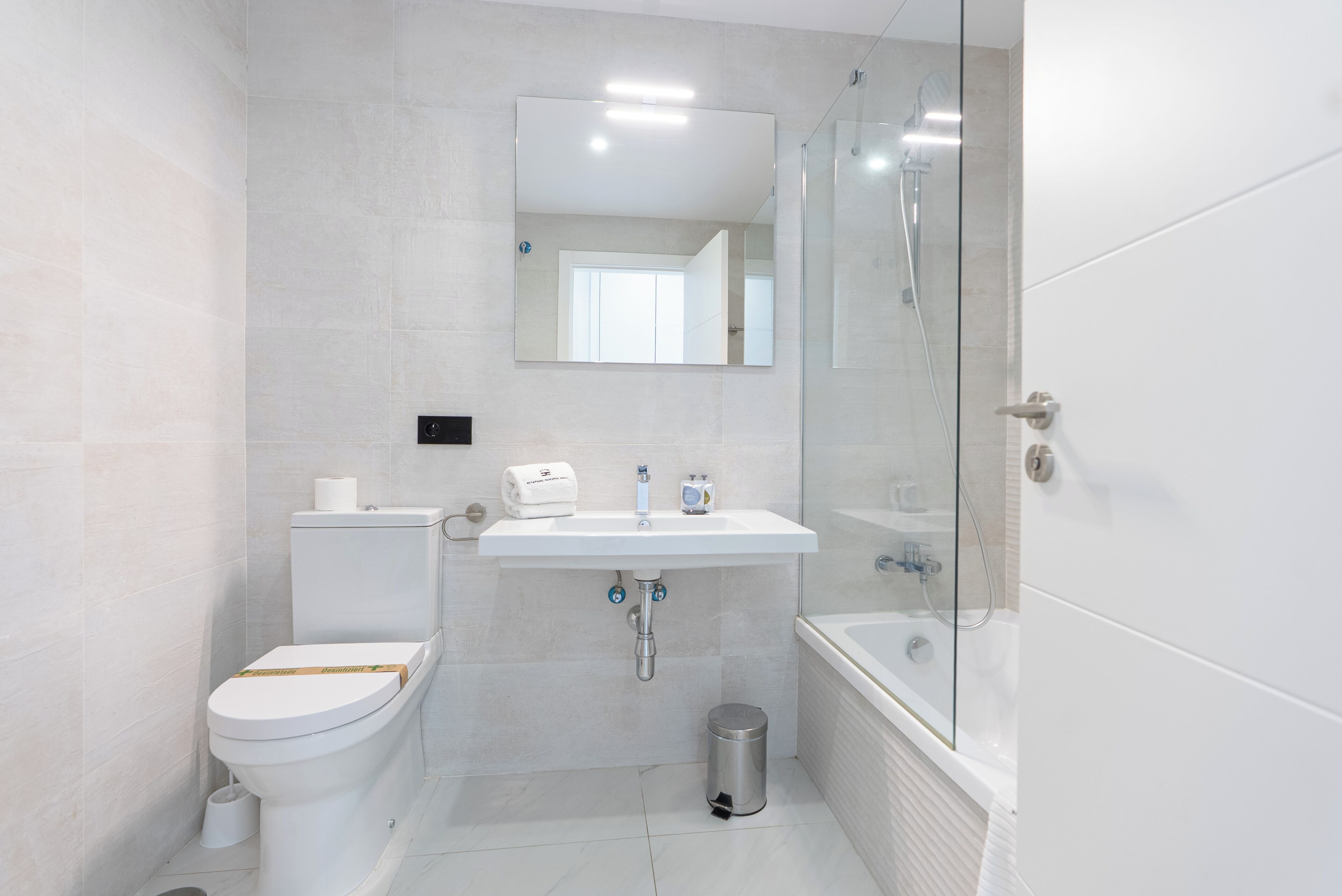 A modern bathroom with a toilet, sink, and bathtub.
