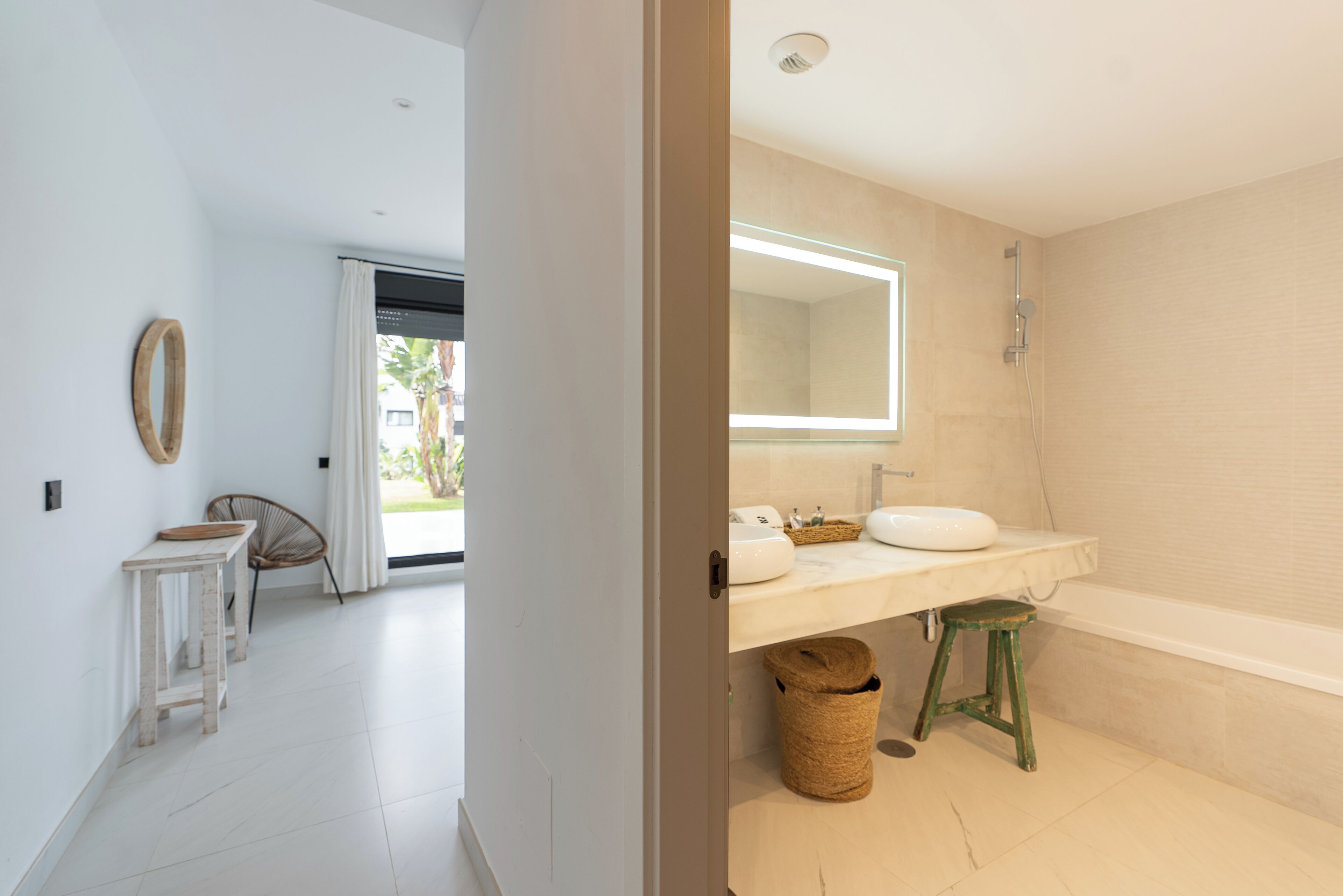 A modern bathroom with a large mirror, a bathtub, and a sink.