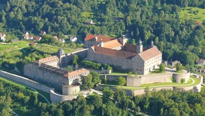 A historic castle complex with multiple buildings, a fortified wall, and a moat. - Korbstadthotel Krone (Lichtenfels)
