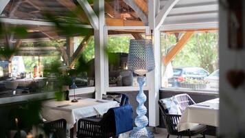 Un comedor interior con mesas, sillas y una lámpara decorativa.