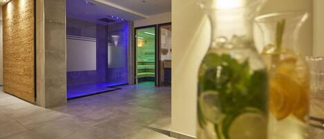 Een moderne hotel lobby met een glazen wand, een waterpartij en een receptiebalie.