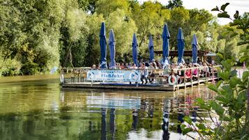 Ein Boot mit blauen Sonnenschirmen und einem Schild, das eine Bootsfahrt anbietet.