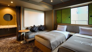 A hotel room with a sofa bed, a small round table, a sink, and a window with a view of a building. - eph TAKAYAMA (Takayama)