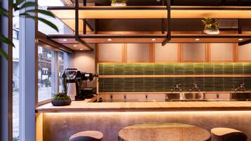 Una cocina moderna con mostradores de madera, salpicadero verde e iluminación colgante.