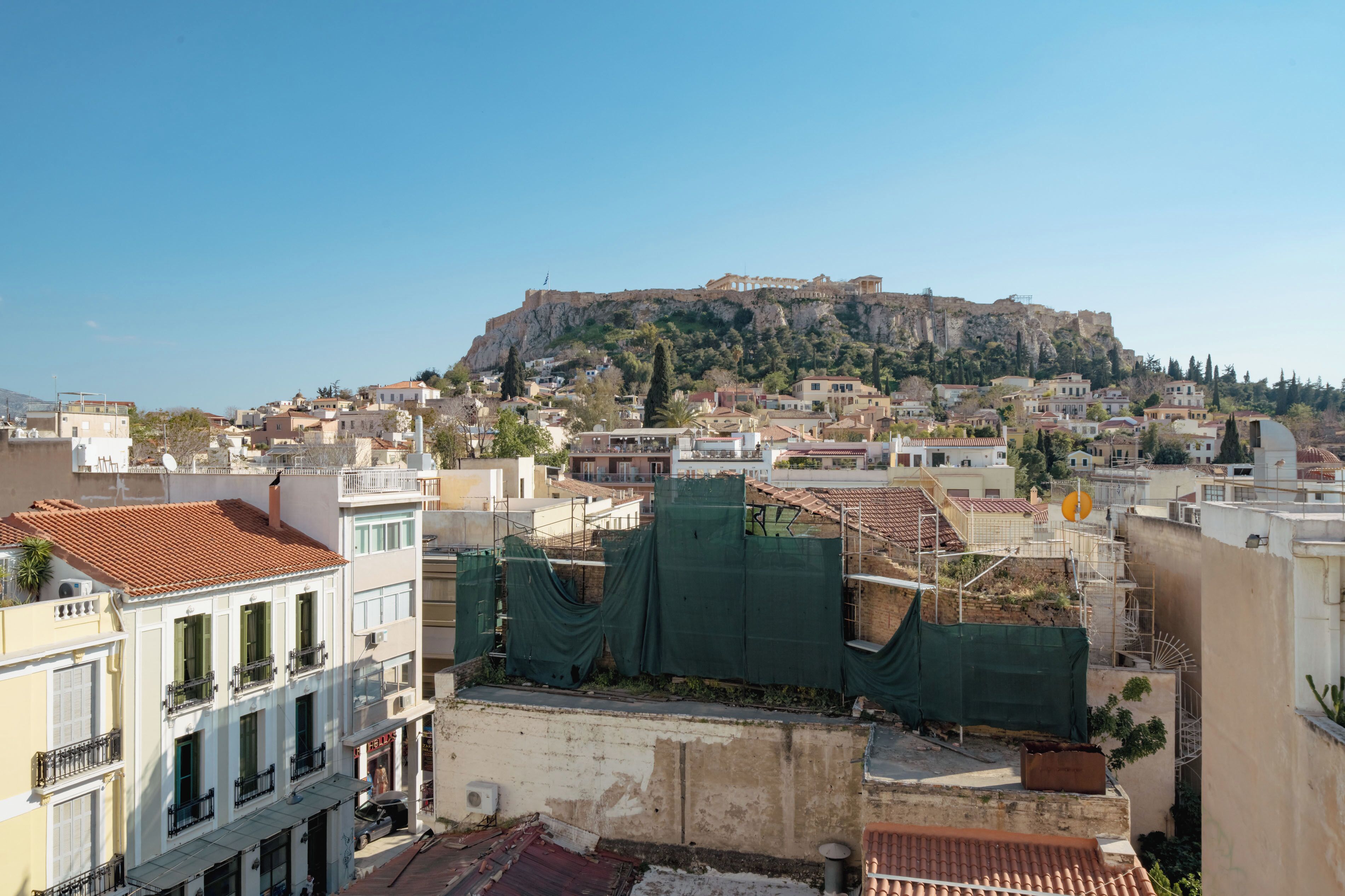 Une vue urbaine avec une colline imposante en arrière-plan, qui semble être un site historique.