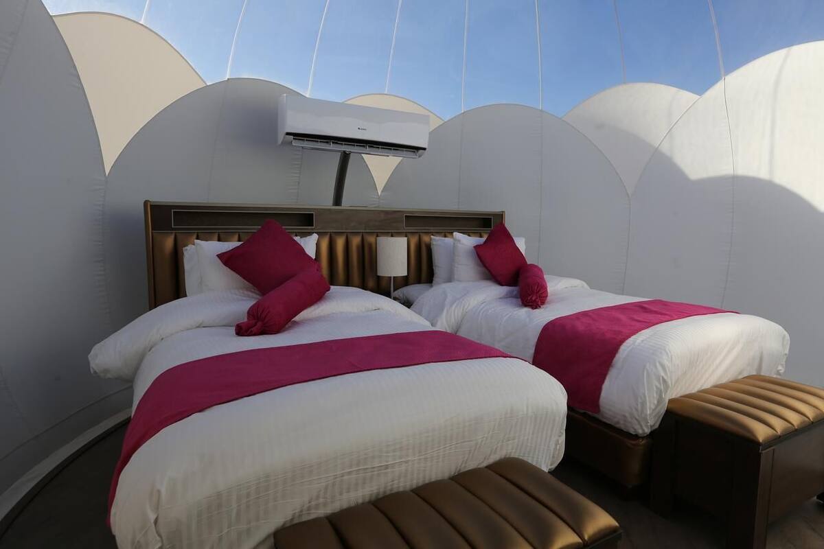 Une chambre d’hôtel avec deux lits, un ventilateur de plafond et une grande fenêtre.