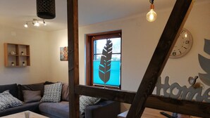 Ett mysigt vardagsrum med en soffa, ett soffbord och en vägg som har en dekorativ träpanel.