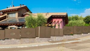 A modern house with a sloped roof, solar panels, and a gated entrance. - B&B Sweet Life (Peschiera del Garda)
