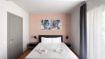 A modern hotel room with a large bed, a painting on the wall, and a view of the city.