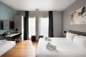 A hotel room with a bed, a desk, a chair, a TV, and a painting on the wall. - 21 House of Stories Città Studi (Milan)