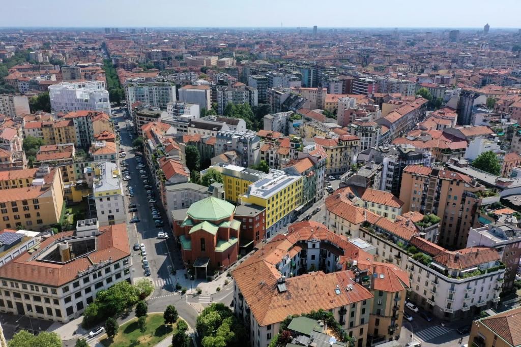 A densely packed urban area with a variety of building styles and a prominent green-roofed structure in the center.