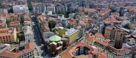 A densely packed urban area with a variety of building styles and a prominent green-roofed structure in the center.