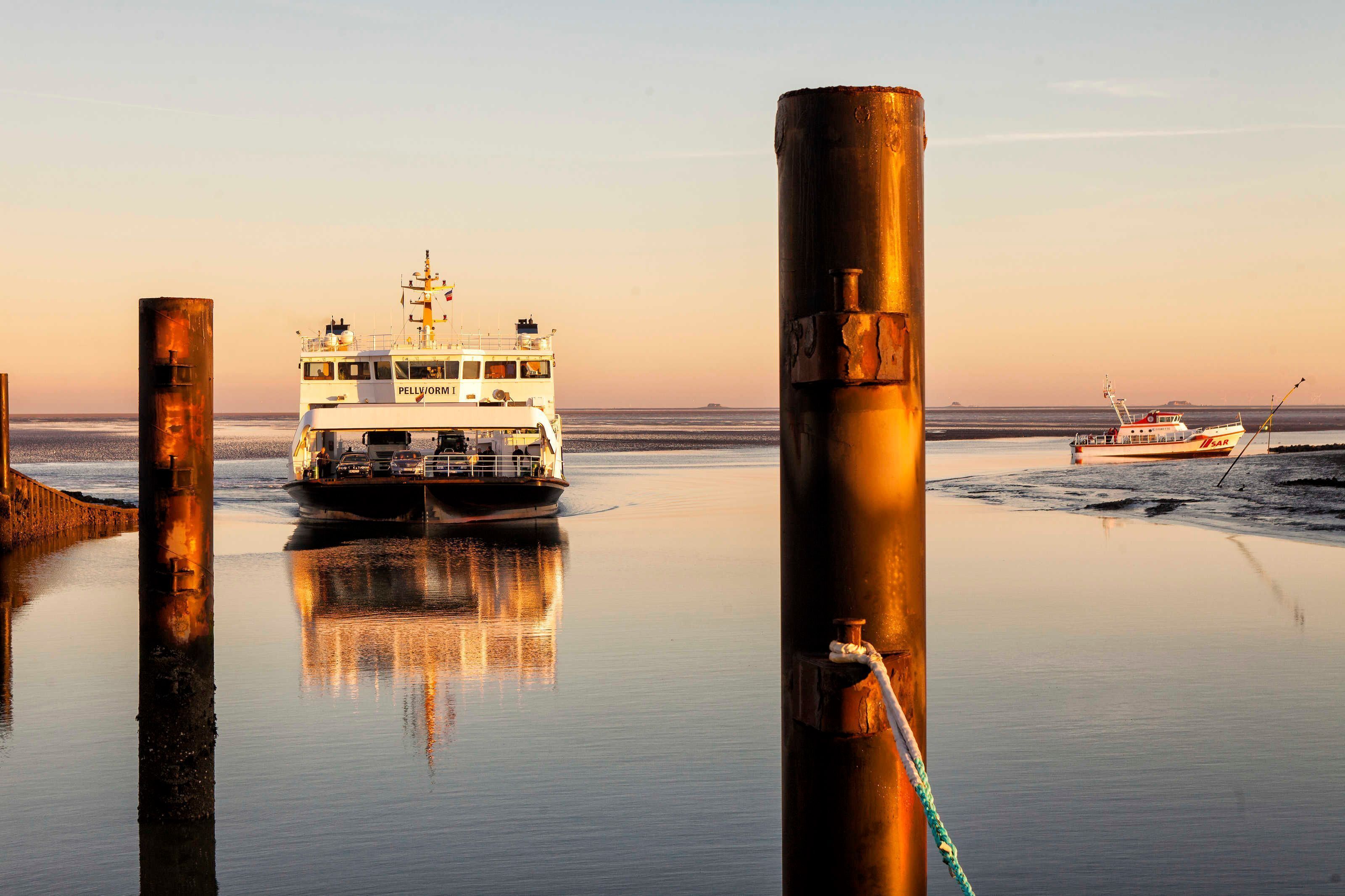 Een veerboot aangemeerd aan een steiger, met een rustige zee en heldere lucht.
