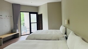Ein Hotelzimmer mit zwei Betten, einer Bank, einer Schiebetür zum Balkon und einer Wandleuchte.