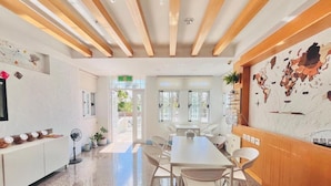 A modern hotel lobby with a long reception desk, white chairs, a large map on the wall, and a wooden ceiling. - Li Ting B&B (Hengchun)