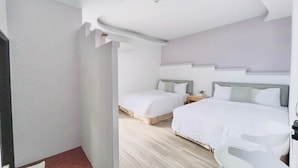 A modern hotel room with two beds, a desk, and a chair. - Li Ting B&B (Hengchun)